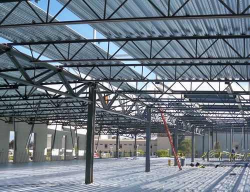A Medical building under construction with an partially constructed roof.