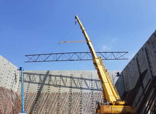 A tilt up warehouse with a crane lifting STMF into place for the roof.