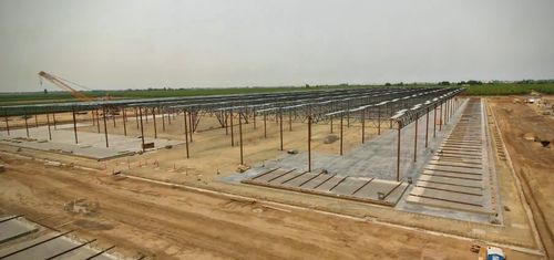 Steel frame of a warehouse in place with tilt up walls laying on the ground ready to be put in place.